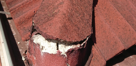Picture of a broken red roof with white crack inside
